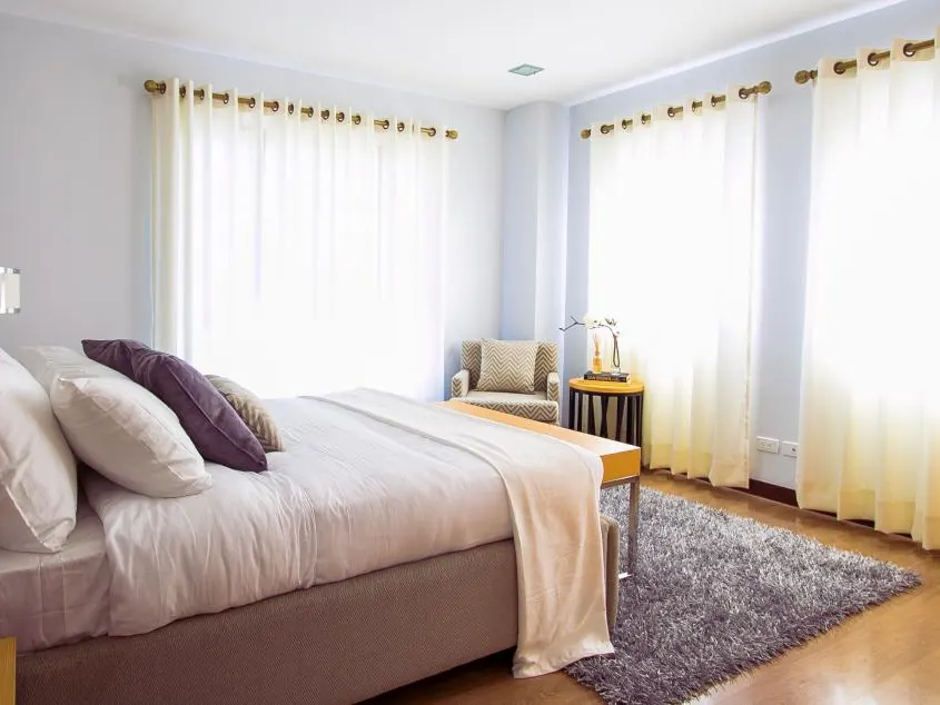 Quarto claro com cama de casal arrumada